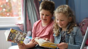 Two children reading books together