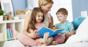 Woman reading with two children